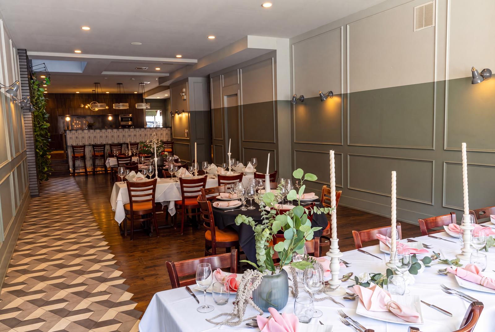 Long tables set with candles, greenery and pink napkins
