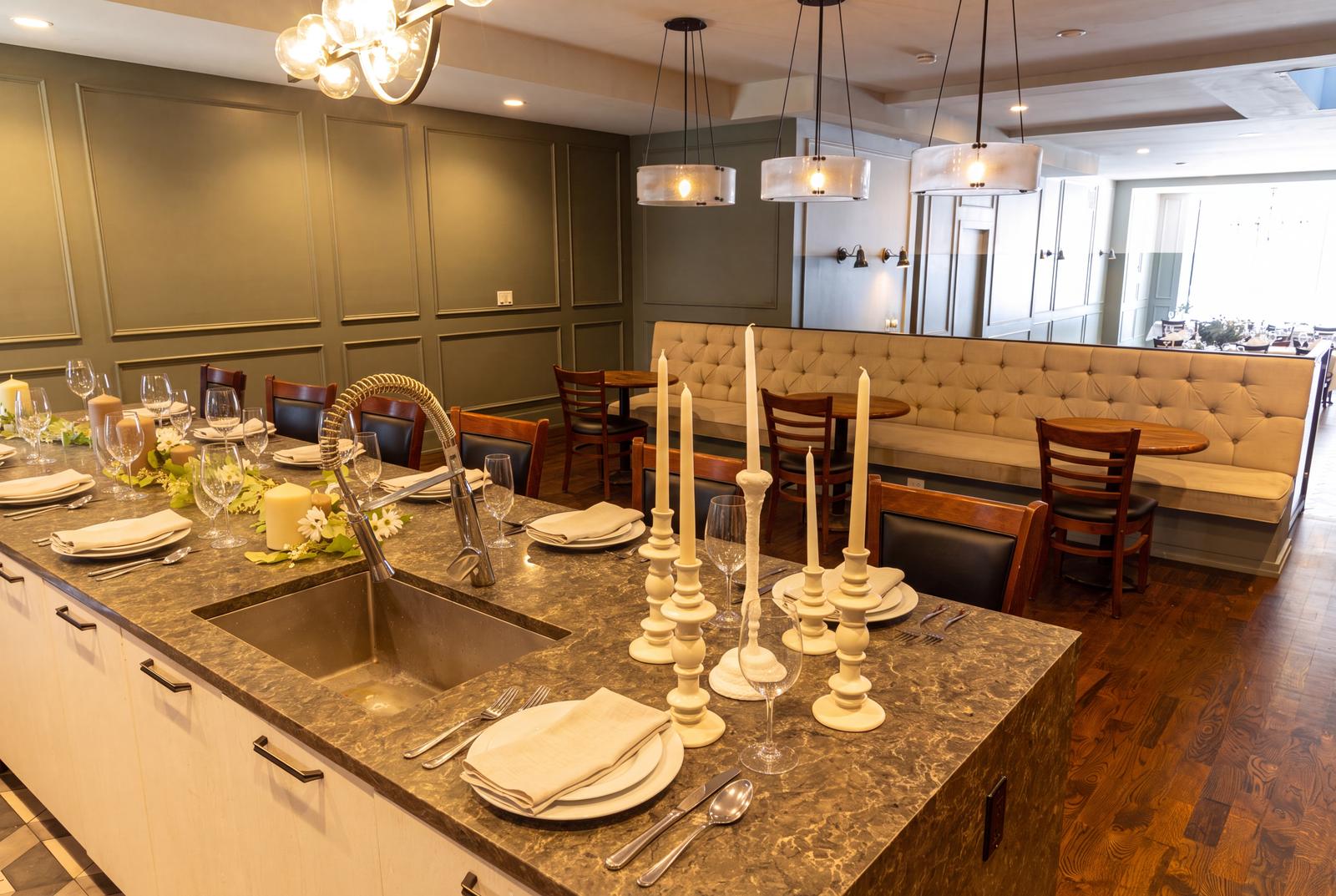 The stone counter set with candles and place settings, with banquette seating beyond